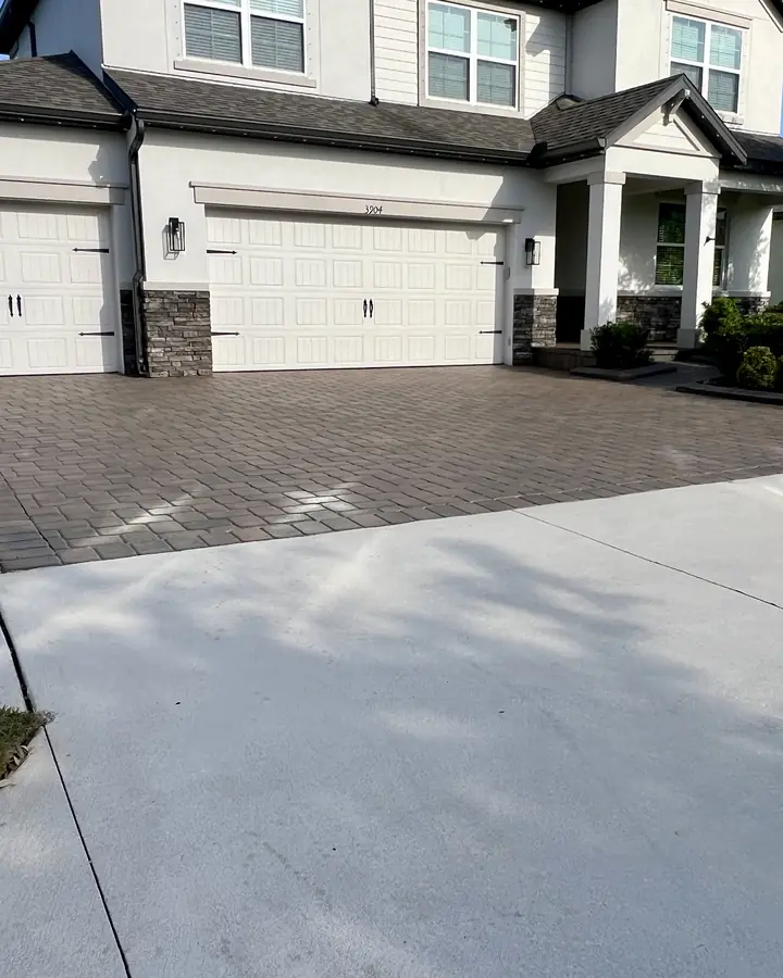 Sealed paver driveway leading to a two-story home